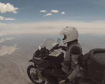 Riding a motorcycle on mirrored salt flats looks like flying in the sky!